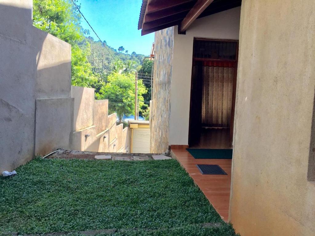 a house with a yard of grass next to a door at Lucky Home Kandy in Ampitiya
