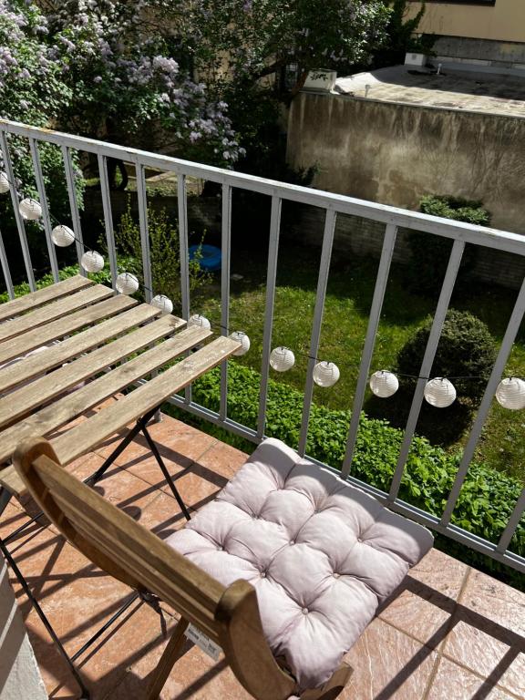 un banco de madera con un asiento acolchado en el balcón en Private Room In A Big Ol’ Flat en Praga