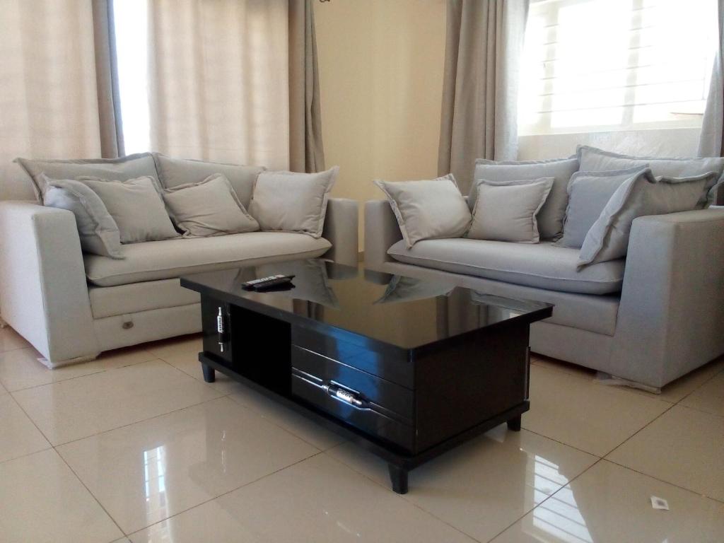 een woonkamer met 2 banken en een salontafel bij Kulu Lodge Apartments in Lusaka
