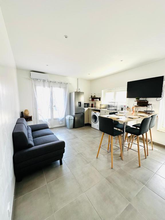 un salon avec un canapé, une table et des chaises dans l'établissement P’tit bonheur, au Grau-dʼAgde