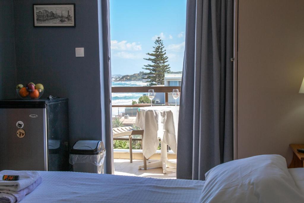 Un dormitorio con una cama y vista a un balcón. en Nefeli Rooms, en Agia Marina de Nea Kydonia