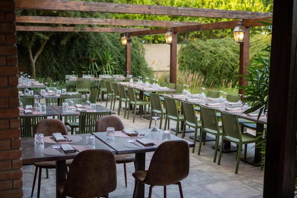 jadalnia ze stołami i krzesłami w ogrodzie w obiekcie Agriturismo Parco delle Querce w mieście Valentano
