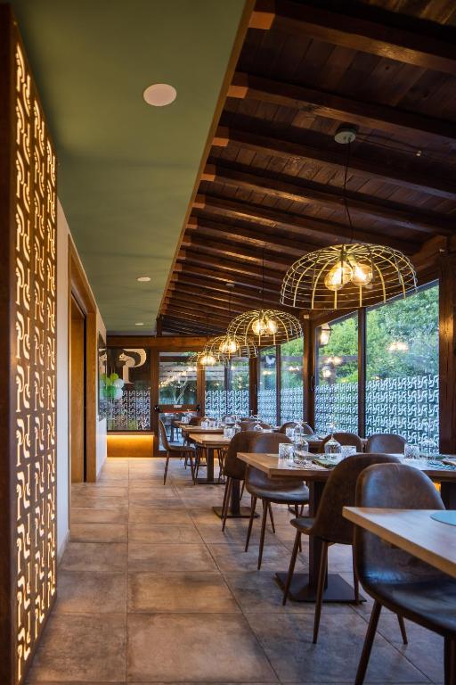 jadalnia ze stołami, krzesłami i żyrandolami w obiekcie Agriturismo Parco delle Querce w mieście Valentano