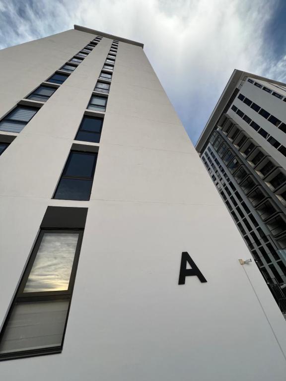 a tall white building with the letter a on it at Departamento frente al TSM in Torreón