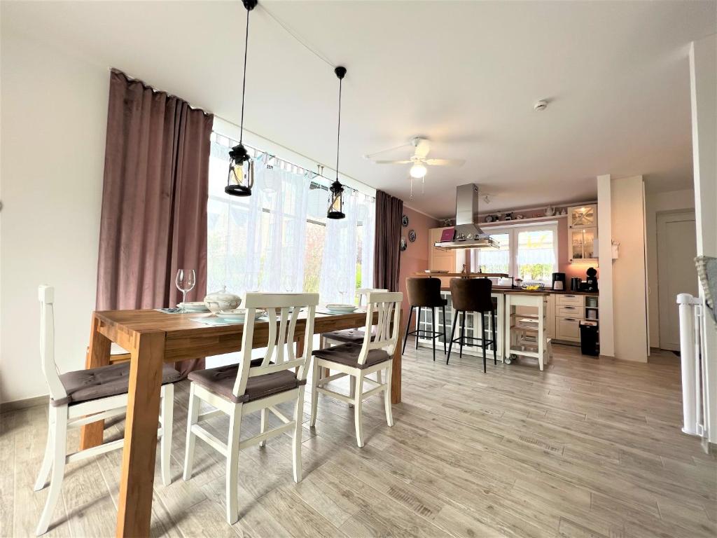 une salle à manger et un salon avec une table et des chaises dans l'établissement Haus Undine, Deichhörn 6a, à Dangast