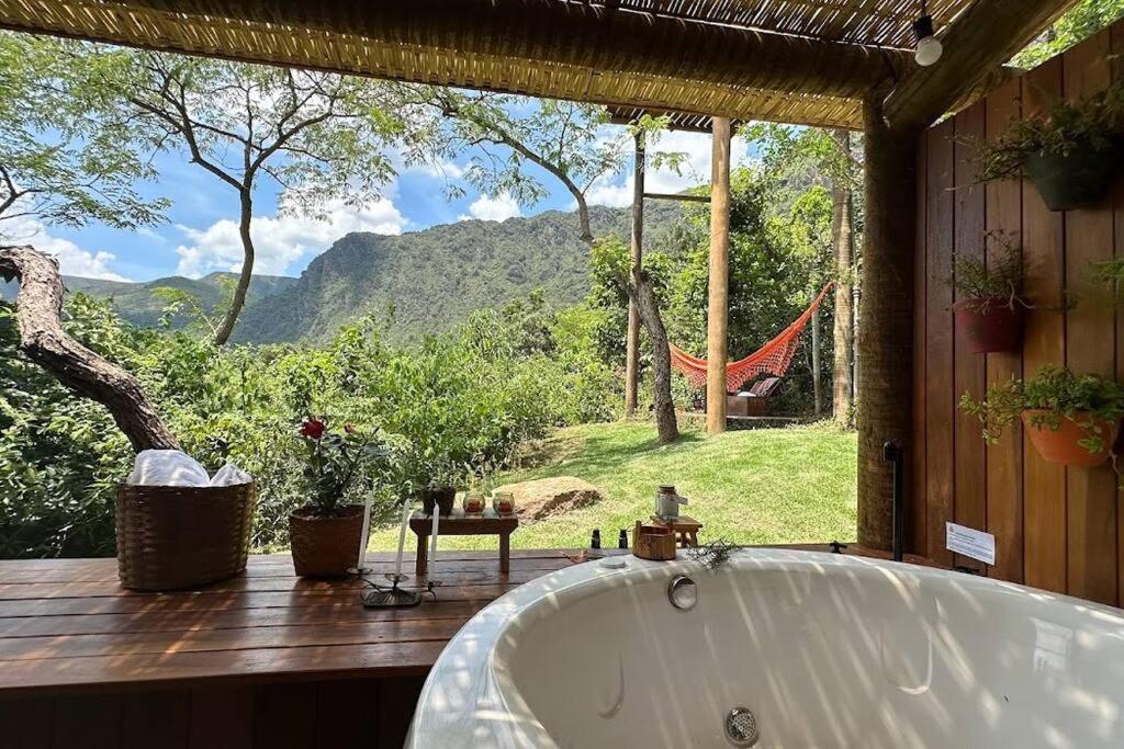 uma banheira num quarto com vista para uma rede de descanso em Cabanas da Mata - Cabana Flamboyant - Casa Branca em Brumadinho