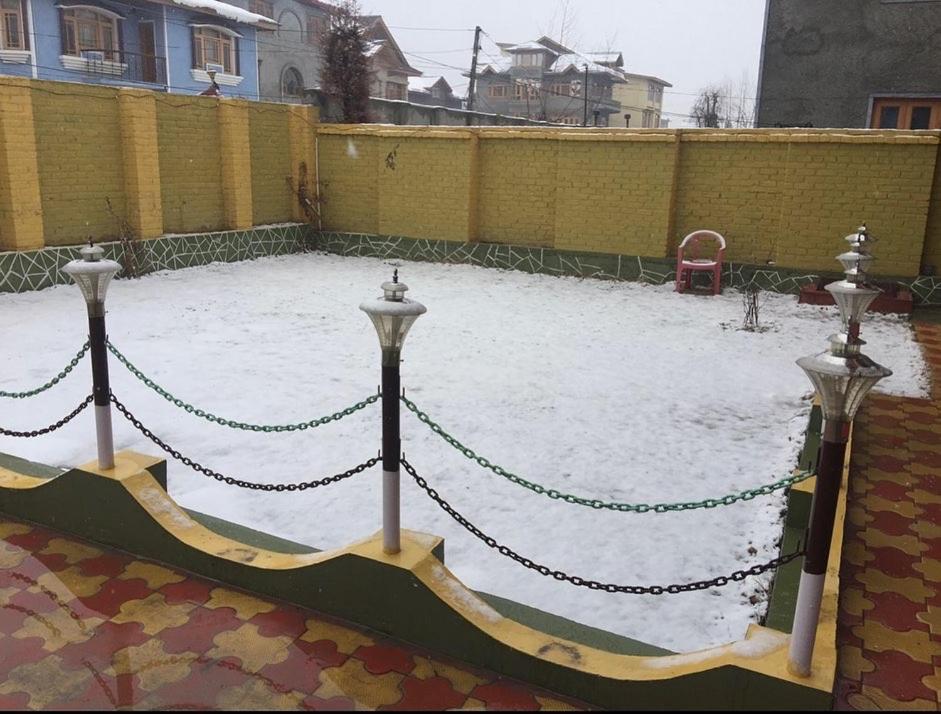 a chain link fence with snow on it at KaShMiR ViBeS HoMeStAy Family Room in Srinagar