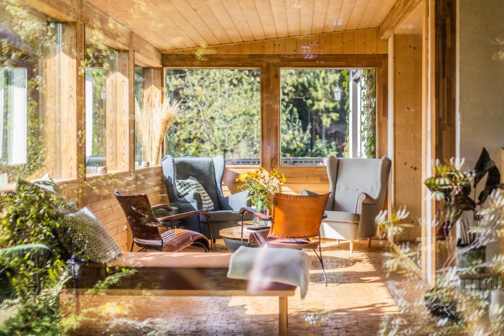 a screened in porch with chairs and a couch at Willa Zwolakówka in Istebna