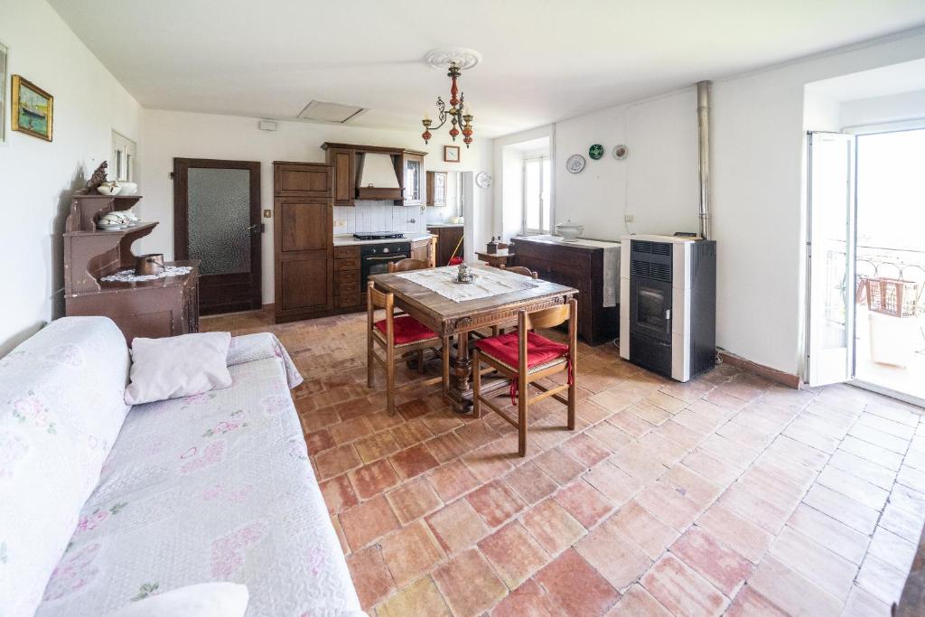 ein Wohnzimmer mit einem Tisch und einer Küche in der Unterkunft Casa dell'Alfiere in Gabbiana
