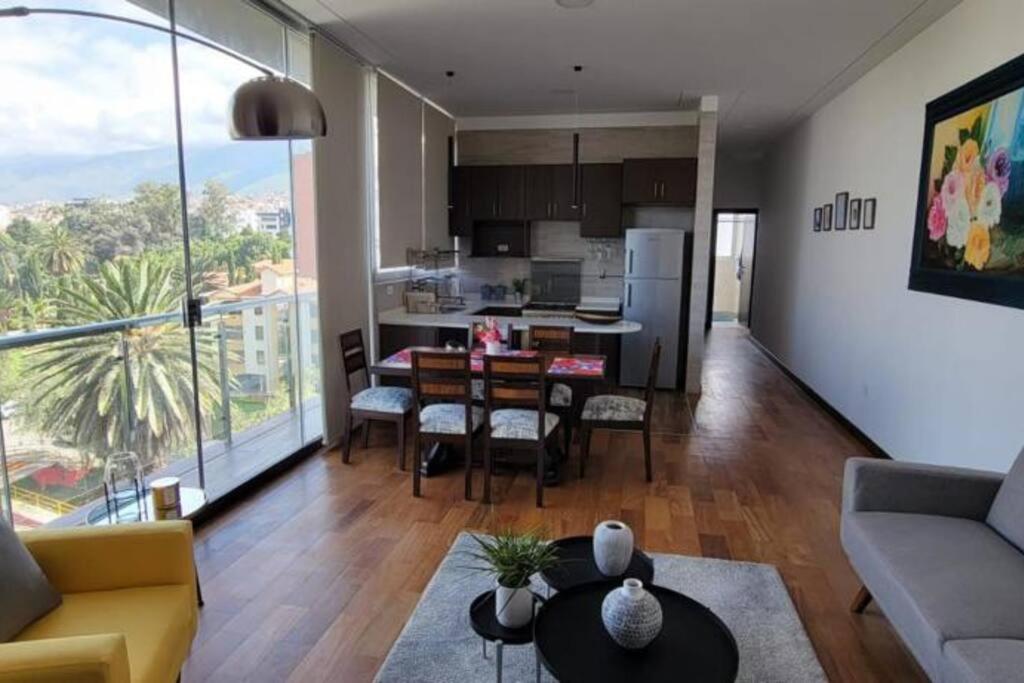 a living room with a kitchen and a dining room at Hermoso departamento sobre Av. America cerca al Sombrero de Chola in Cochabamba