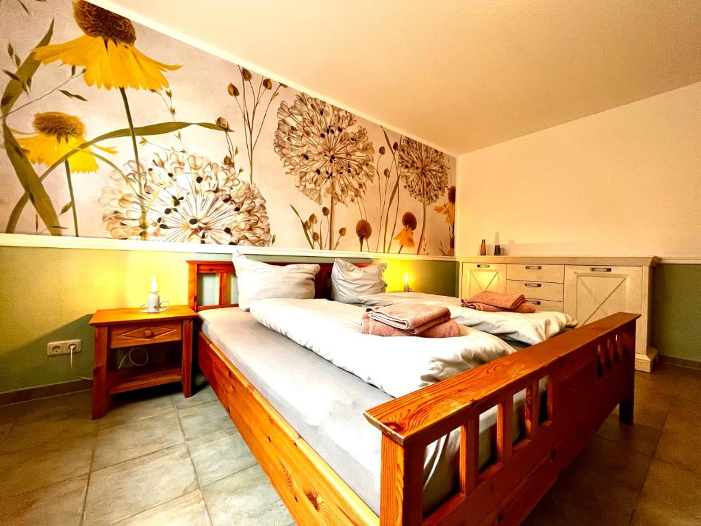 - une chambre avec un grand lit orné d'une fresque florale dans l'établissement Ferienwohnung Waldliebe, à Schierke