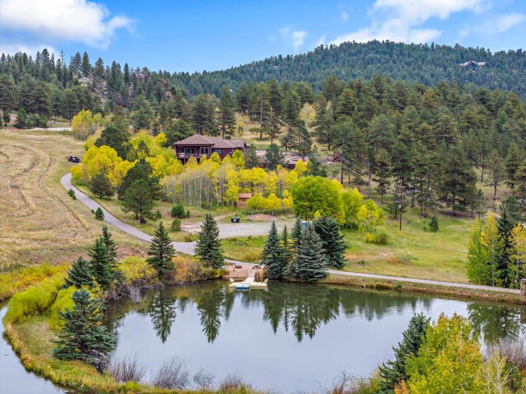 einem Luftblick auf einen See mit einem Haus in der Unterkunft Lone Rock Mountain Retreat w Views & Private Lake in Bailey