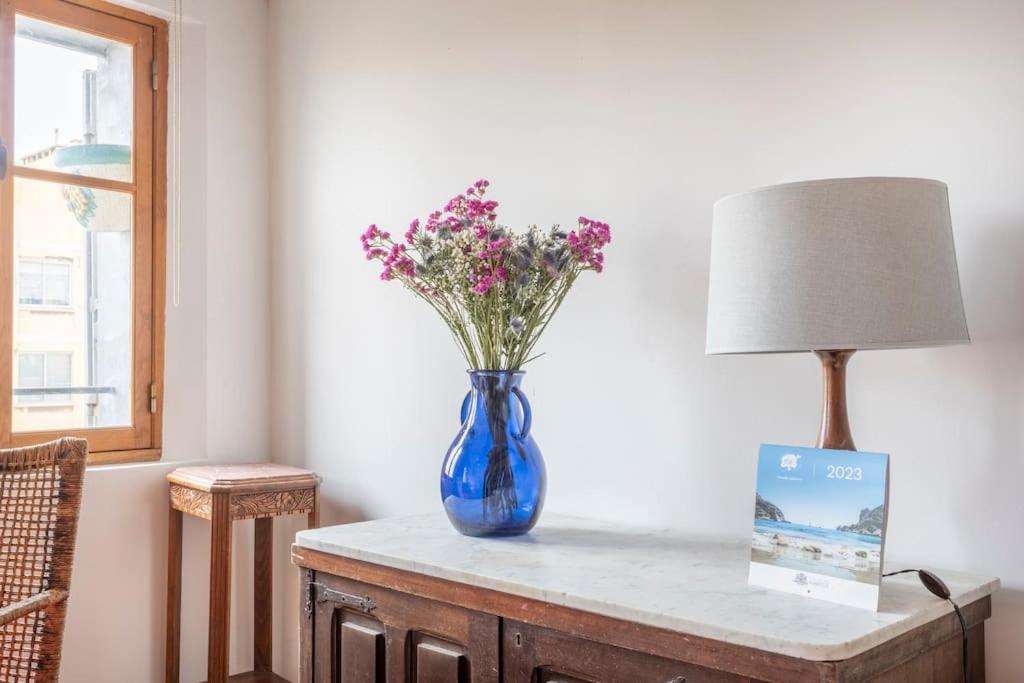 馬賽的住宿－Le Caisserie - Cosy studio Marseillais - Panier，灯边的一张桌子上花的蓝色花瓶