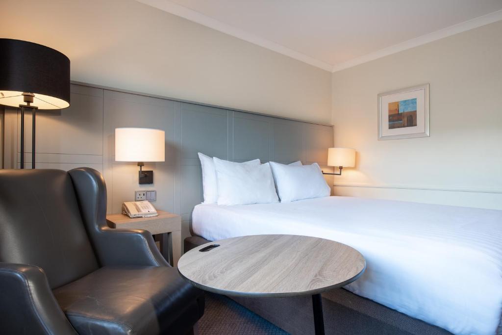 a hotel room with a bed and a table and a chair at Holiday Inn Edinburgh Zoo, an IHG Hotel in Edinburgh