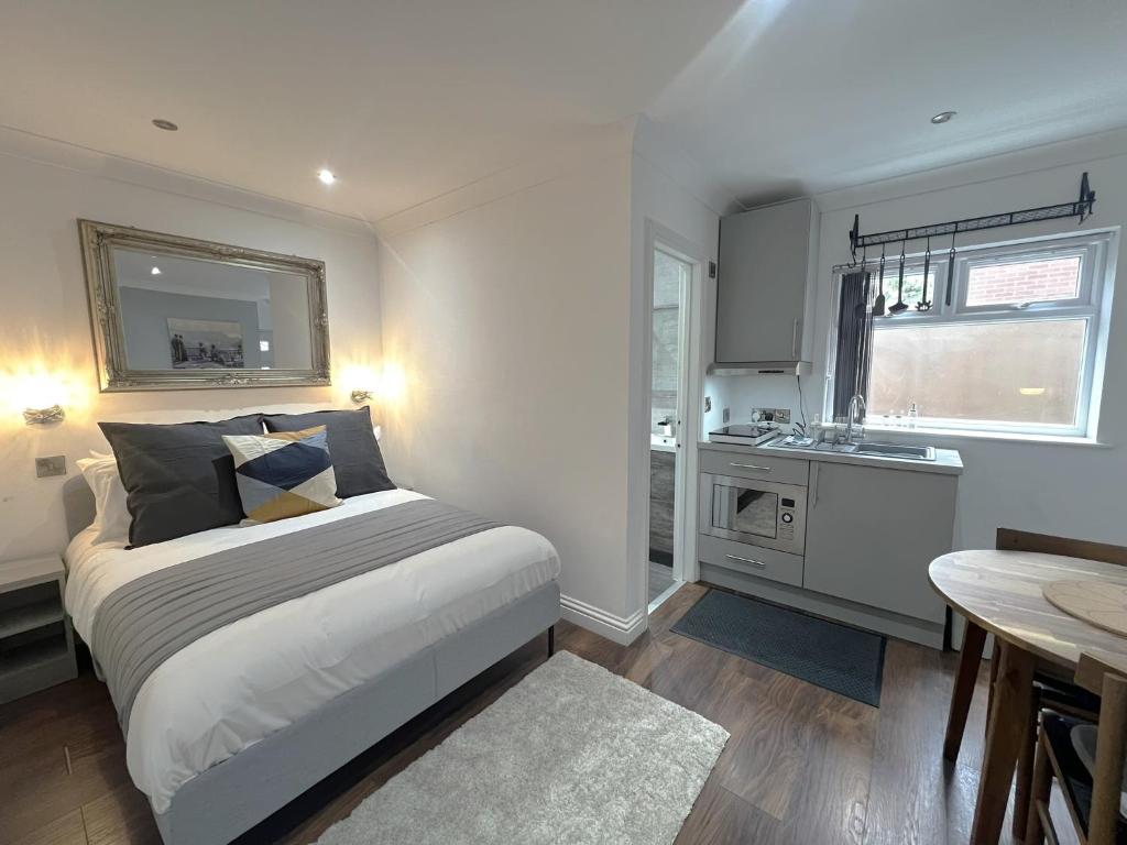 a bedroom with a large bed and a kitchen at Melbury Rooms & Studios in Exeter