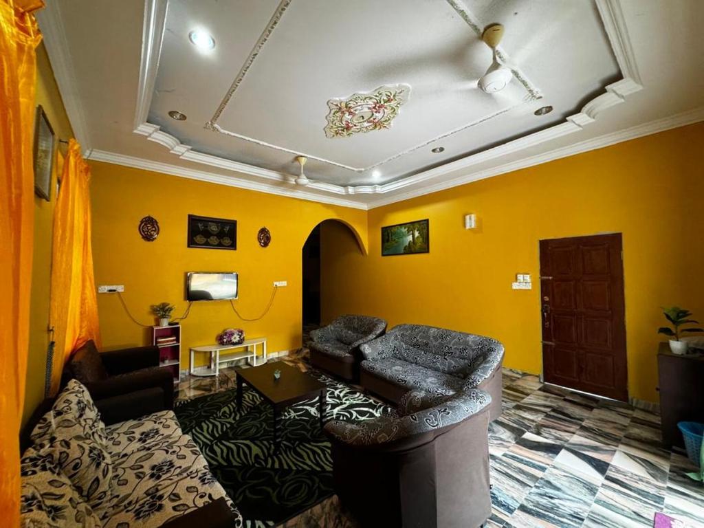 Kampung Bota Kiri的住宿－Marbel Villa，带沙发和黄色墙壁的客厅