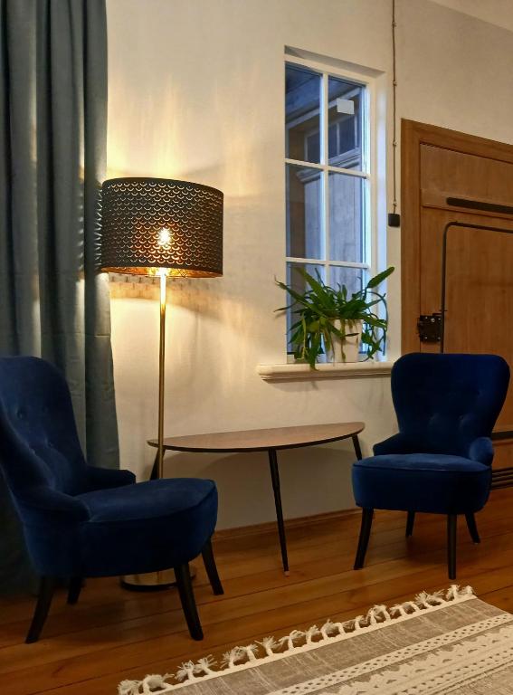 a living room with two chairs and a table and a window at Tūrisma mītne ZVIEDRI in Līgatne