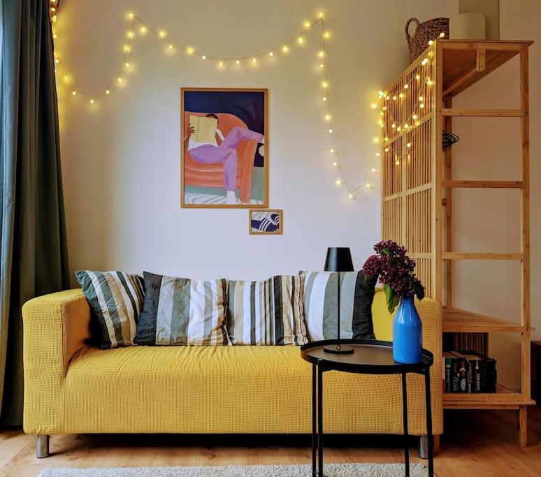 Apartment mit Balkon in Hannover-Ahlem في هانوفر: غرفة معيشة مع أريكة صفراء وطاولة