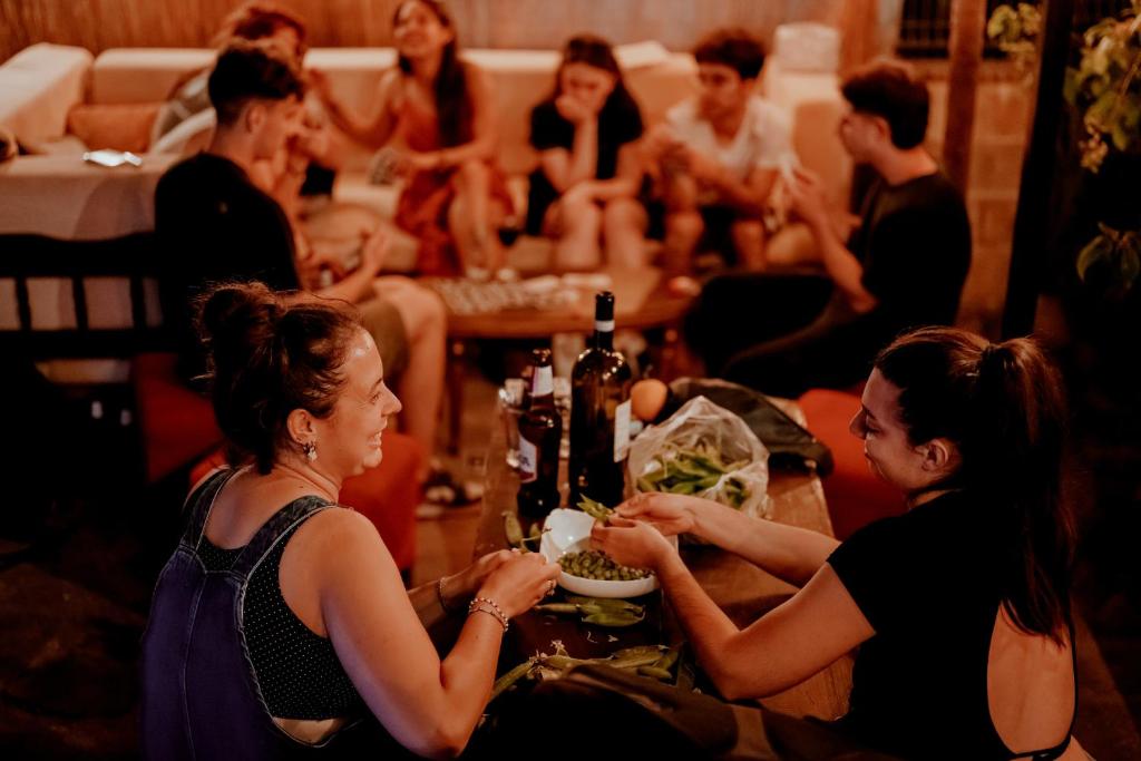 Eine Gruppe von Menschen, die an einem Tisch sitzen und Essen essen. in der Unterkunft Berat Backpackers Hostel in Berat