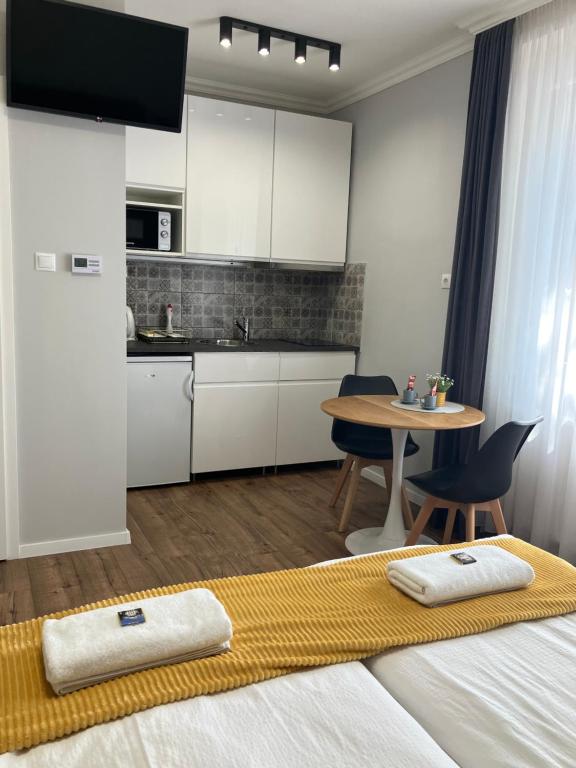 a bedroom with a bed and a table and a kitchen at ILLA Apartments in Eger
