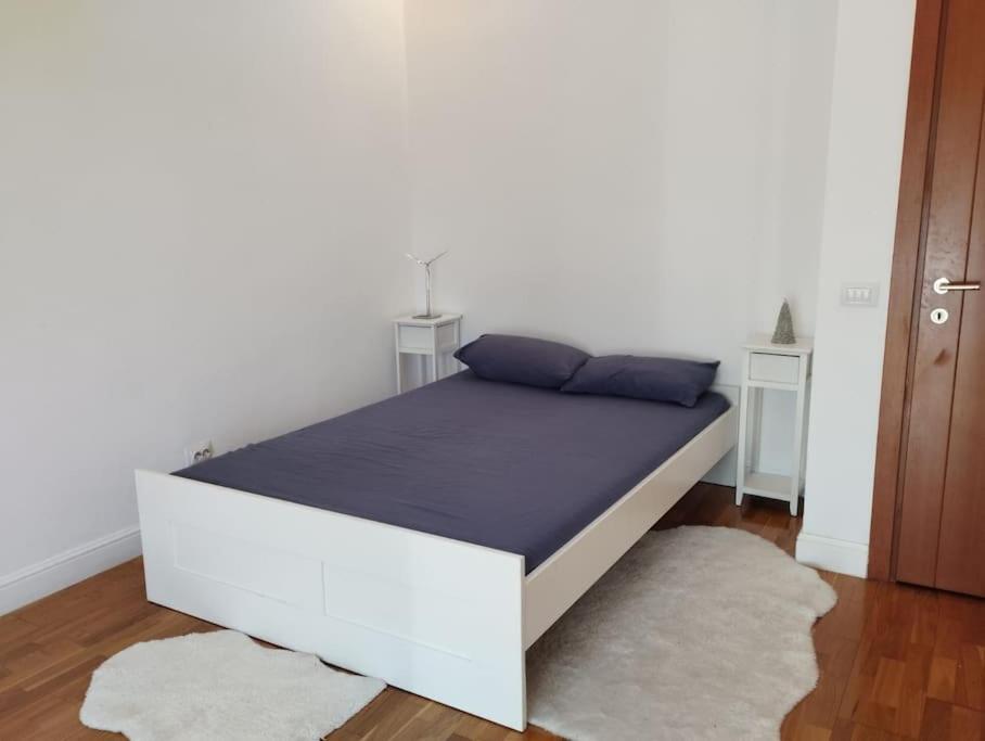 ブカレストにあるPrime 2BDR at Arc de Triumphの白い部屋の白いベッド(青い枕付)