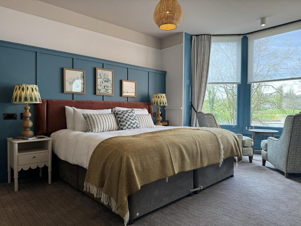 a bedroom with a large bed with blue walls at Mill on the Exe in Exeter
