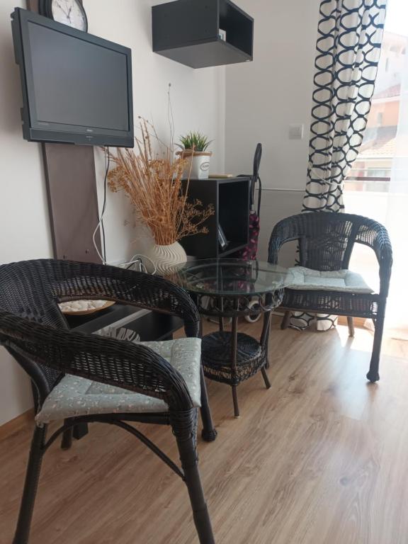 uma sala de estar com cadeiras, uma mesa e uma televisão em Relaks w Marina Cape 88 em Aheloy