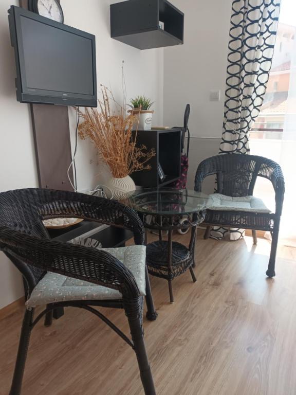 a living room with chairs and a table and a tv at Relaks w Marina Cape 88 in Aheloy