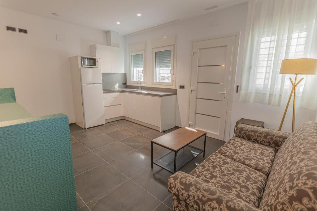 a living room with a couch and a kitchen at Hotel Adiafa in Barbate