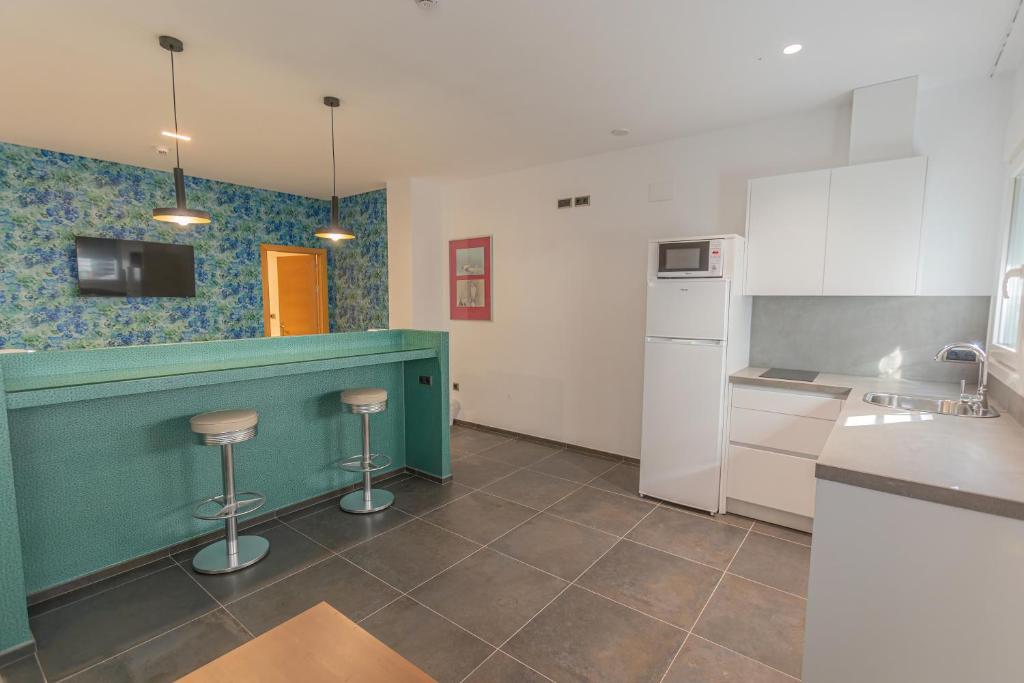 a kitchen with a counter and stools in it at Hotel Adiafa in Barbate