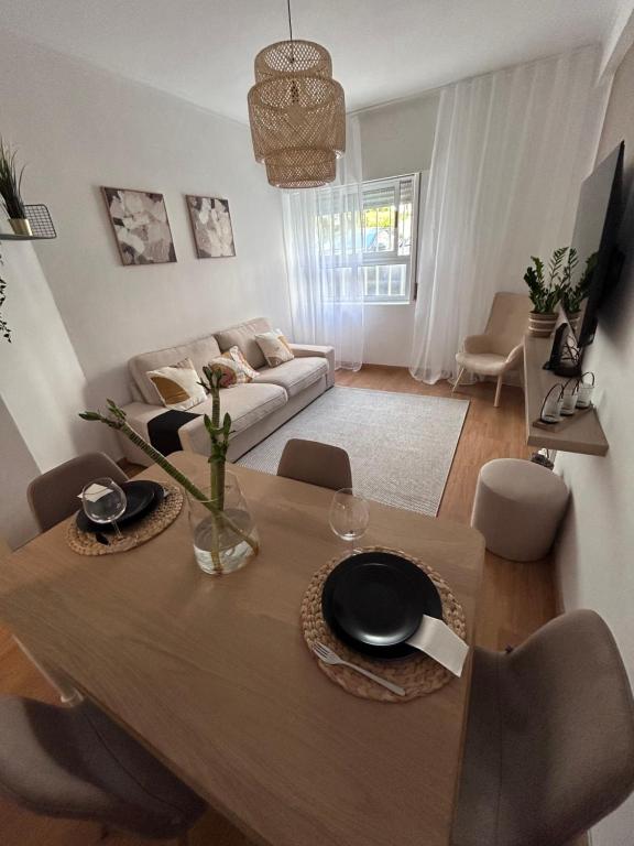a living room with a table and a couch at Apartamento acolhedor em Queluz in Queluz