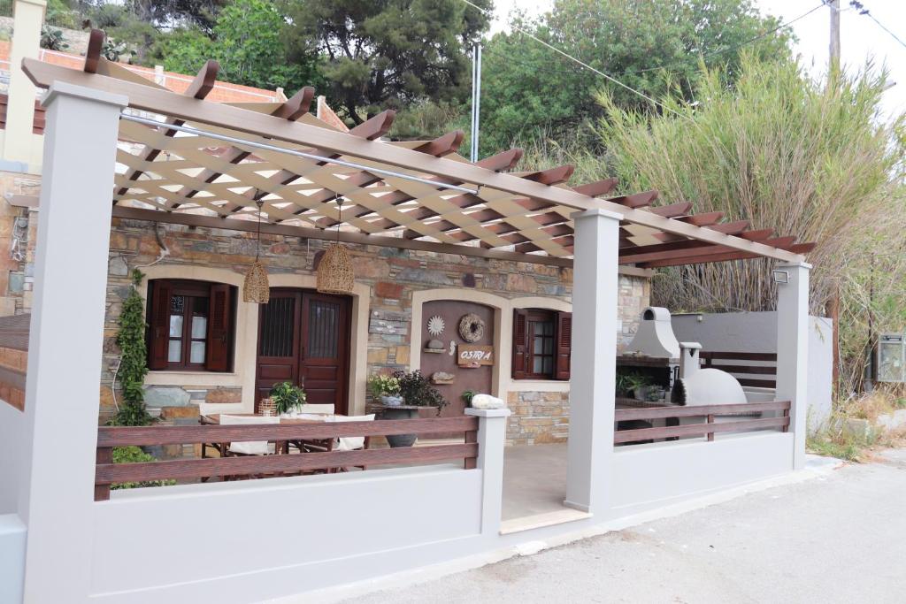 a pergola with a table in front of a building at OSTRIA BOUTIQUE HOME in Kalymnos