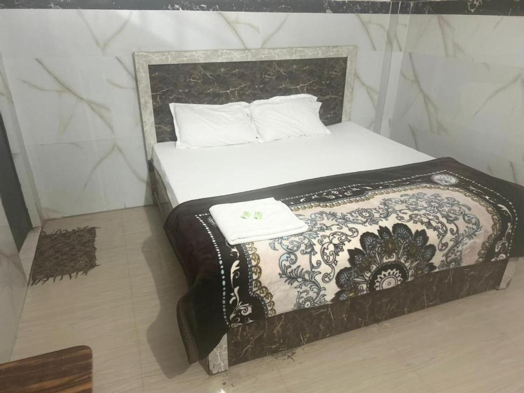 uma cama num quarto com uma almofada branca em Gopesh Dham em Vrindavan