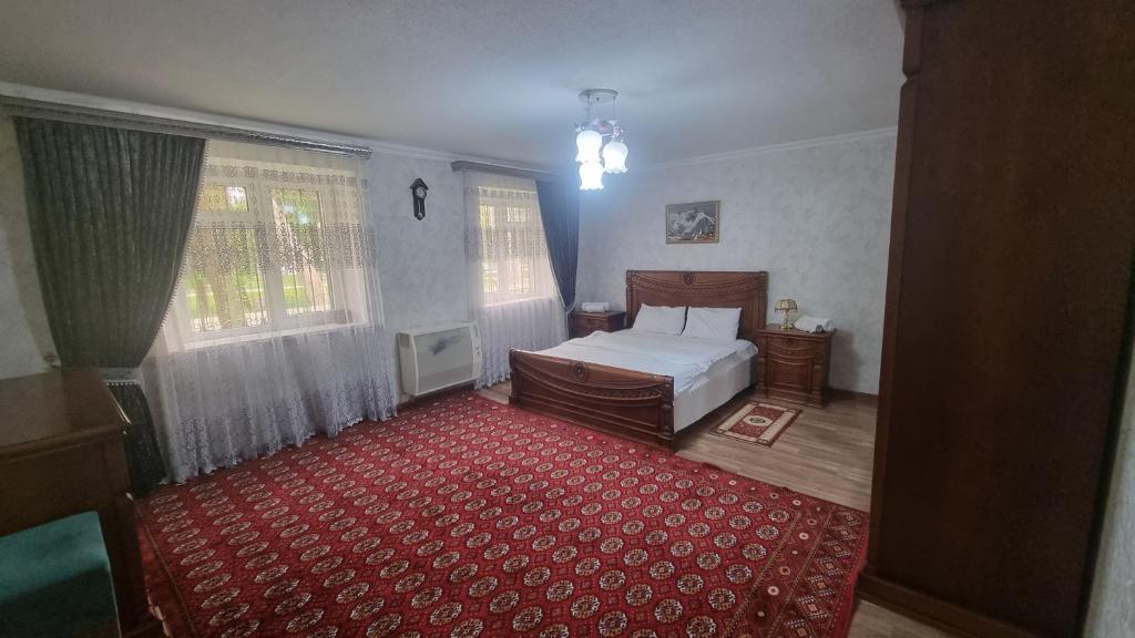 1 dormitorio con 1 cama y alfombra roja en Boulevard Apartment, en Samarkand