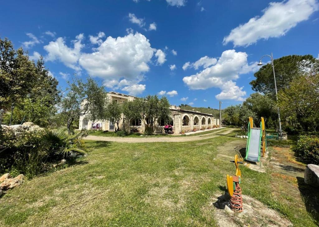 an old building in a park with a yard at Agriturismo PETRA LUCANA in Montescaglioso