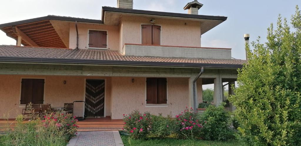 een groot huis met een veranda en een tuin bij Arcobaleno in Pozzolengo