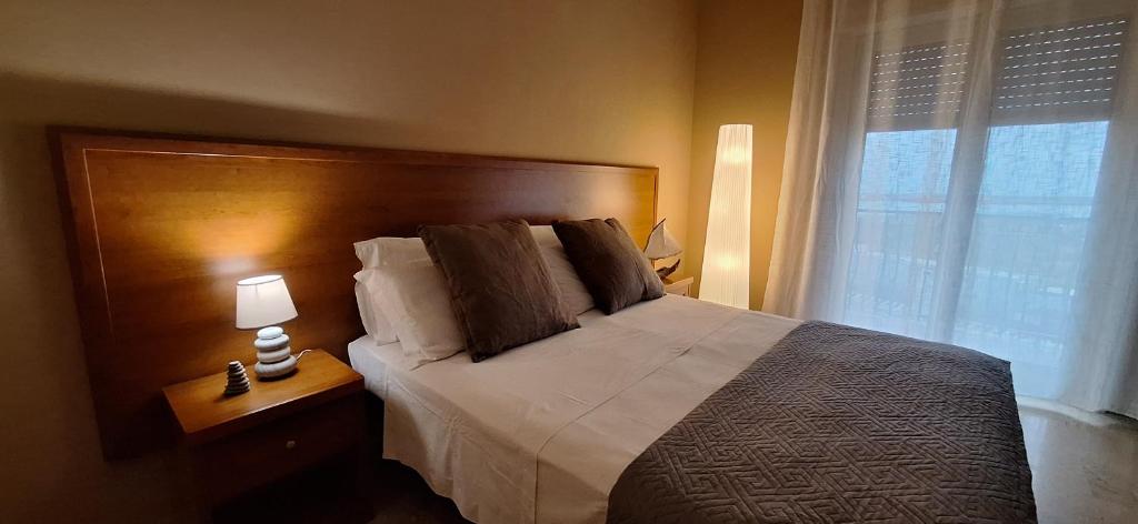 LARANDA rooms في ميلاتسو: غرفة نوم بسرير كبير ونافذة