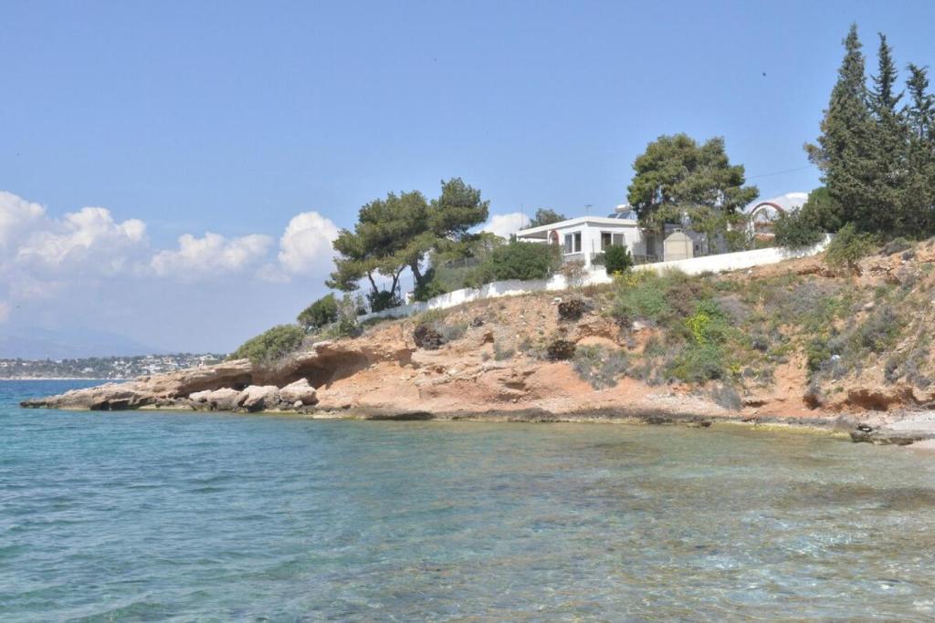 dom na szczycie wyspy w wodzie w obiekcie Salamis Beachfront House w mieście Salamina