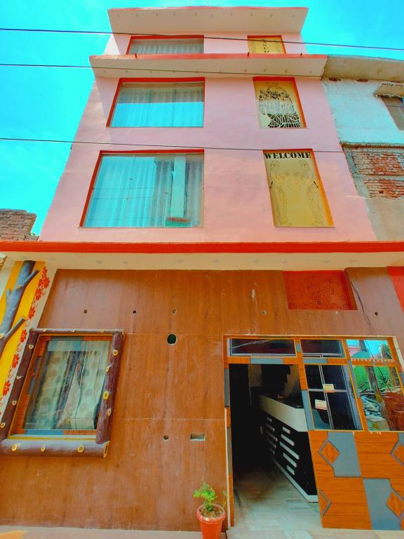 un edificio rosa con ventanas y una puerta en Hotel Vasudeva Palace Near Ram Janam Bhumi en Ayodhya