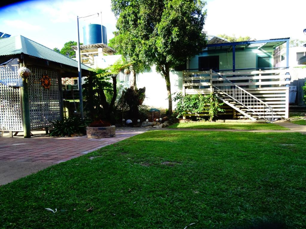 a yard with a house with a staircase and grass at Apurla Island Retreat in K'gari Island (Fraser Island)