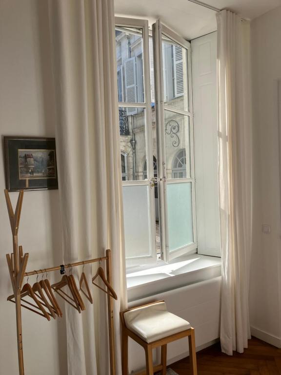 a window with a chair and a white curtain at Chambre dans Hôtel Particulier 18e siècle Hyper Centre La Rochelle in La Rochelle