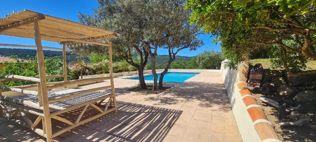 a wooden gazebo sitting next to a swimming pool at Gites Colline De Sollies in Salernes