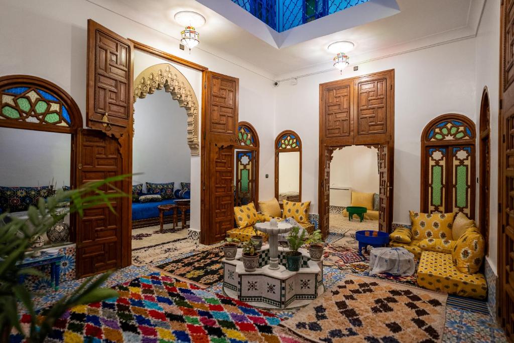 een woonkamer met houten deuren en een kamer met meubilair bij Dar Ribati in Sale