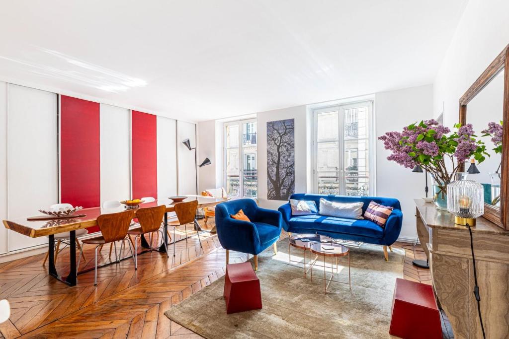 un salon avec un canapé bleu et une table dans l'établissement GuestReady - Elegance in trasbourg-Saint-Denis, à Paris