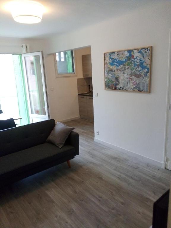 een woonkamer met een bank en een schilderij aan de muur bij Bienvenus ! Appartement jaune in Marseille