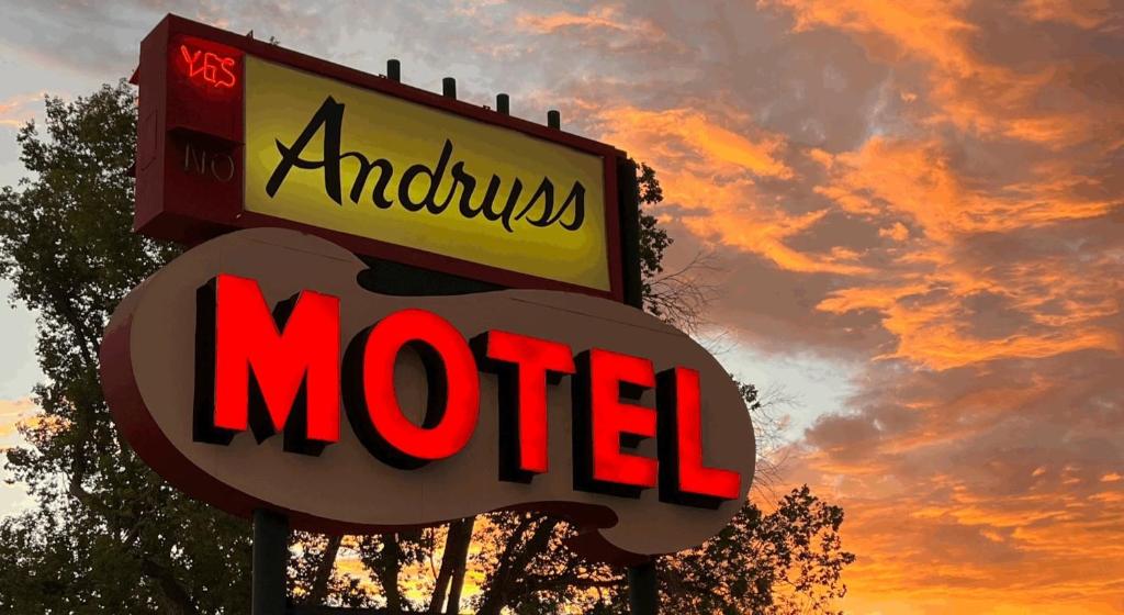 una señal para un motel McDonalds con una puesta de sol en el fondo en Andruss Motel, en Walker