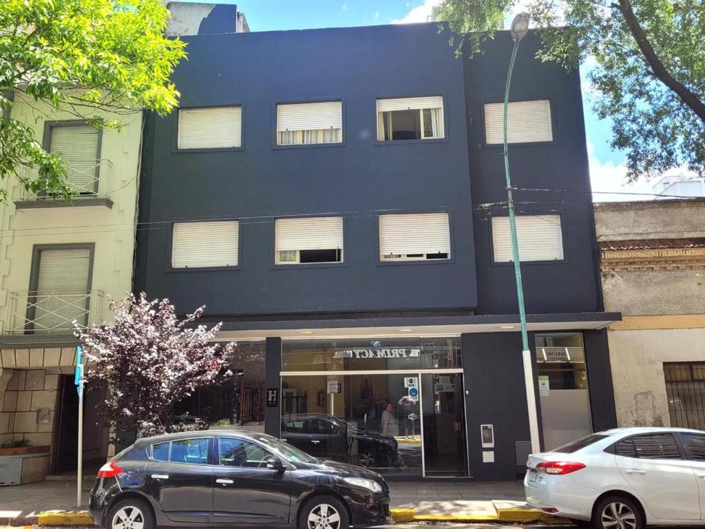 two cars parked in front of a black building at Hotel Canciller in Mar del Plata