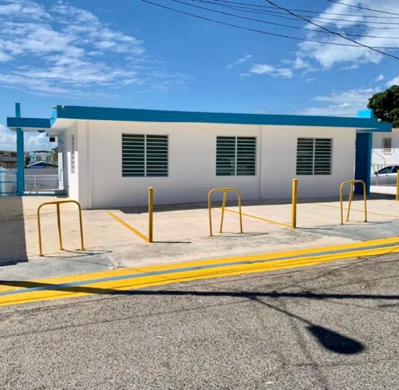 un bâtiment avec des barrières jaunes en face d'une rue dans l'établissement Sandy Shores Retreat Beach Apt in Cabo Rojo, à Boqueron
