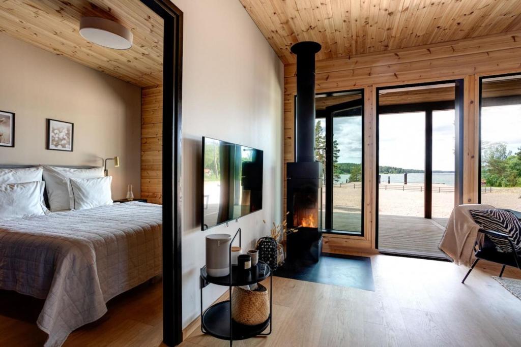 ein Schlafzimmer mit einem großen Bett und einem Kamin in der Unterkunft Saunamaki Resort F - Beachfront in Salo