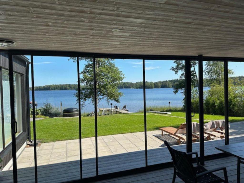 a screened in porch with a view of a lake at Stay North - Villa Katajala in Hämeenlinna